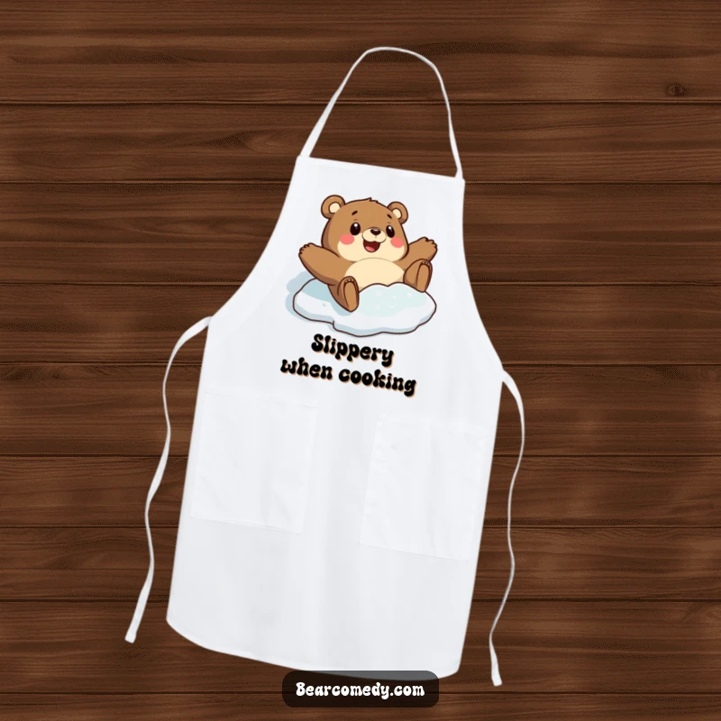 Funny apron featuring a bear character comically sliding on a slick icy patch with a look of surprised delight, ideal for winter cooking.