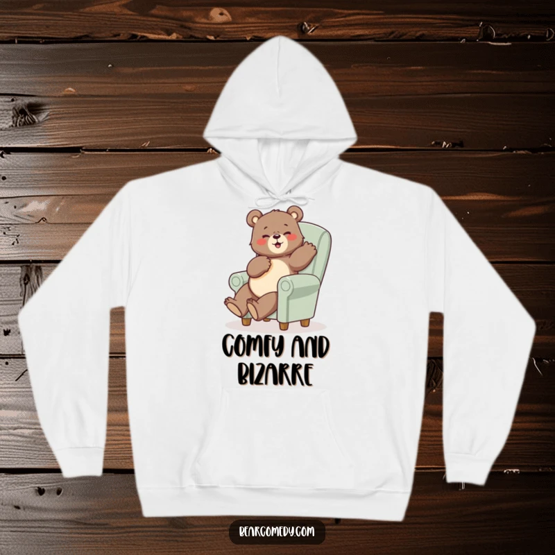 Funny bear hoodie showing a bear in a funny pose perched precariously on a tiny, oversized chair, perfect for cozy laughs.