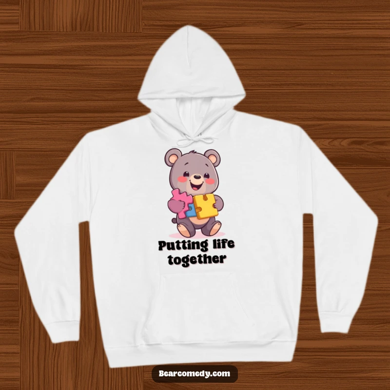 Funny bear hoodie featuring a smiling bear balancing colorful puzzle pieces, offering warmth and a touch of brainy humor.