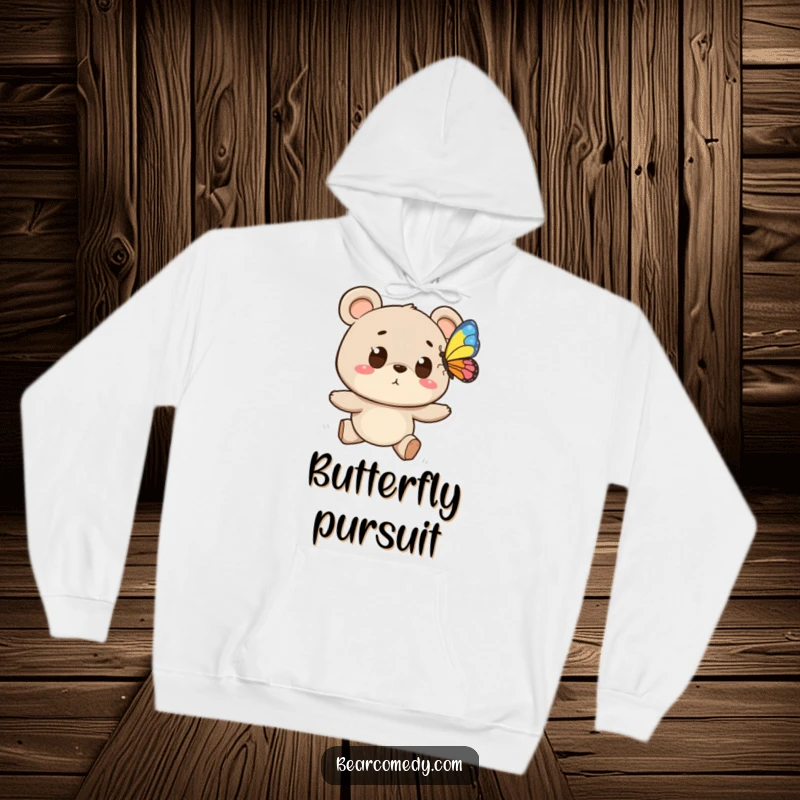 Funny hoodie depicting a bear character with wide eyes enthusiastically chasing a colorful butterfly, ideal for cozy outdoor humor.