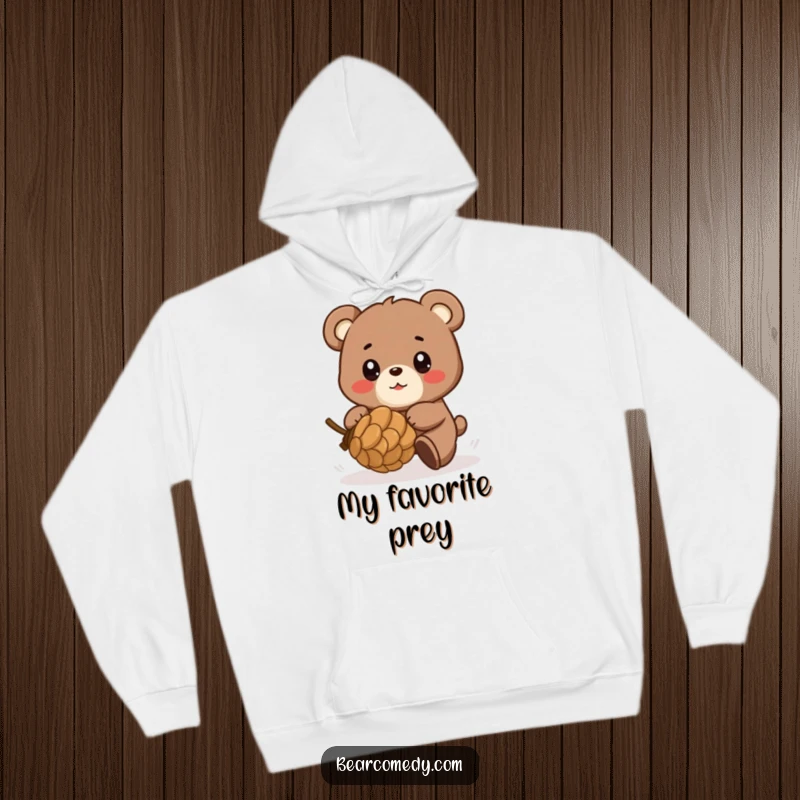 Funny hoodie featuring a bear character in playful pursuit of a rolling pinecone, eyes shining with delight and energetic glee.
