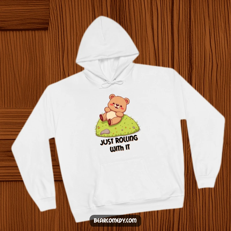 Funny Hoodie depicting a joyful bear creature hilariously rolling down a grassy slope, radiating pure, uninhibited fun and silliness.