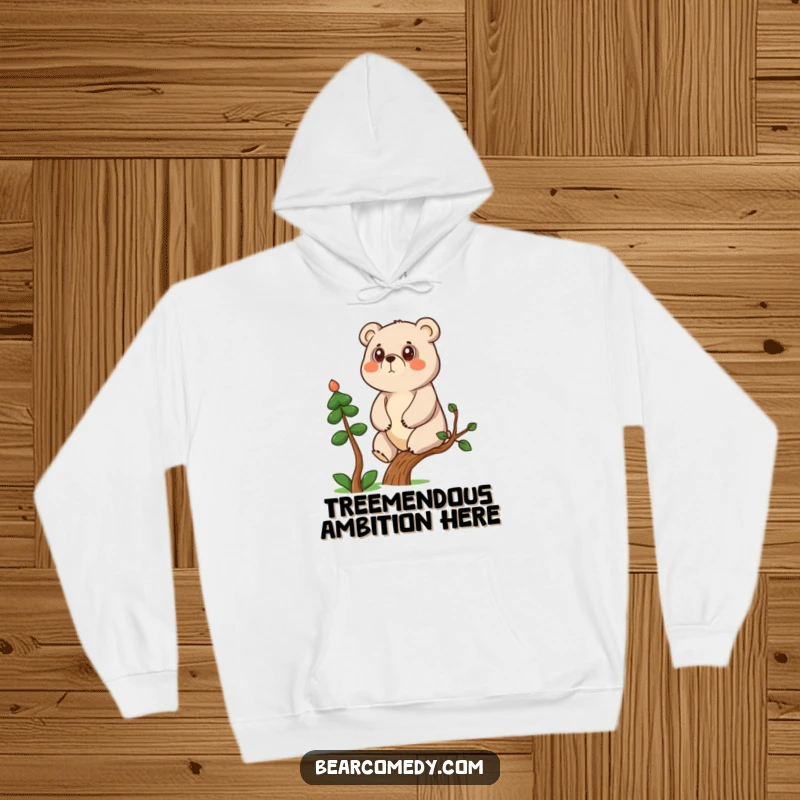 Funny determined bear character climbing a small tree on a cozy hoodie, symbolizing ambition and comfort.