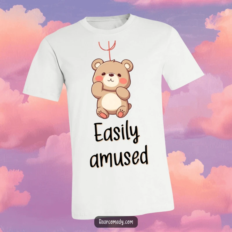 Funny bear t-shirt illustrating a playful bear character actively batting at a bright, dangling string with a focused expression.