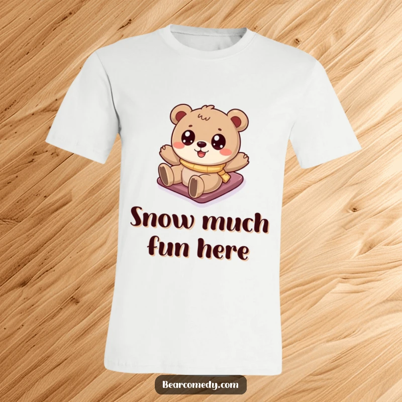 Funny bear t-shirt depicting a cartoony bear with sparkling eyes gleefully sliding down a snow-covered hill, a winter delight.