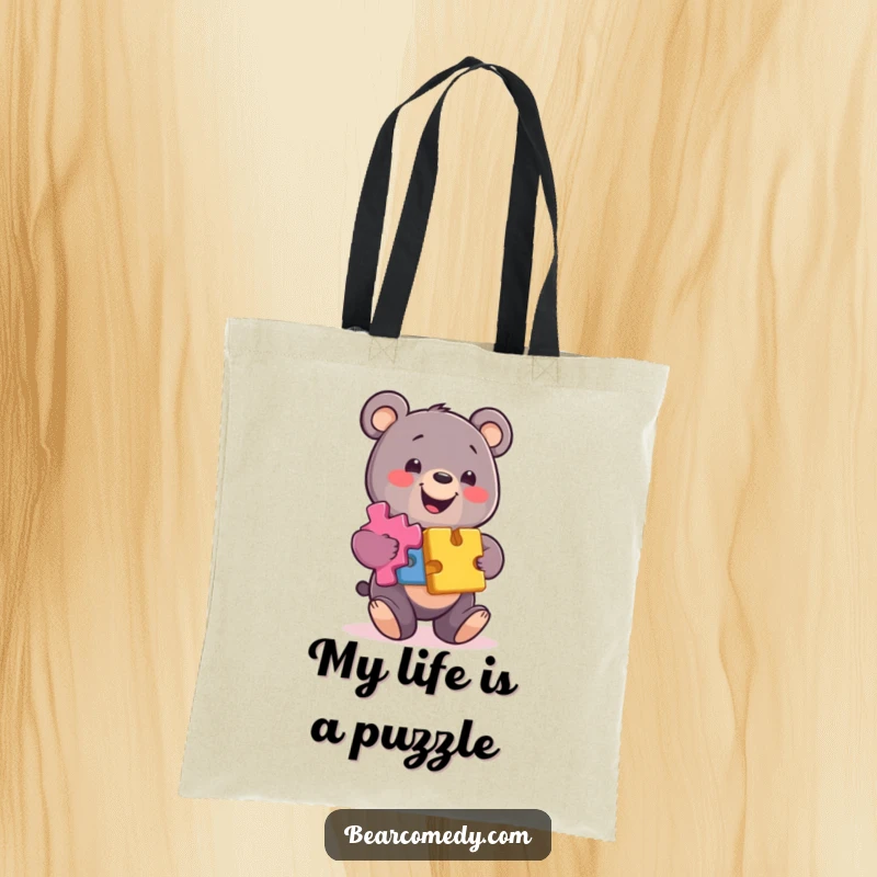Funny bear tote bag featuring a smiling character balancing colorful puzzle pieces, perfect for carrying items with a clever twist.