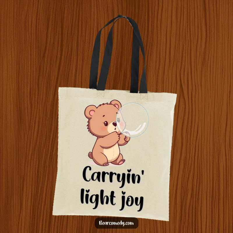 Funny tote bag showing a bear cub playfully batting at a giant, iridescent bubble, perfect for carrying essentials with a touch of fun.