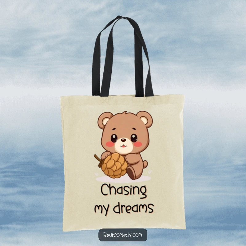 Funny tote bag showcasing a bear character playfully chasing a rolling pinecone, with eyes full of glee, perfect for carrying fun items.