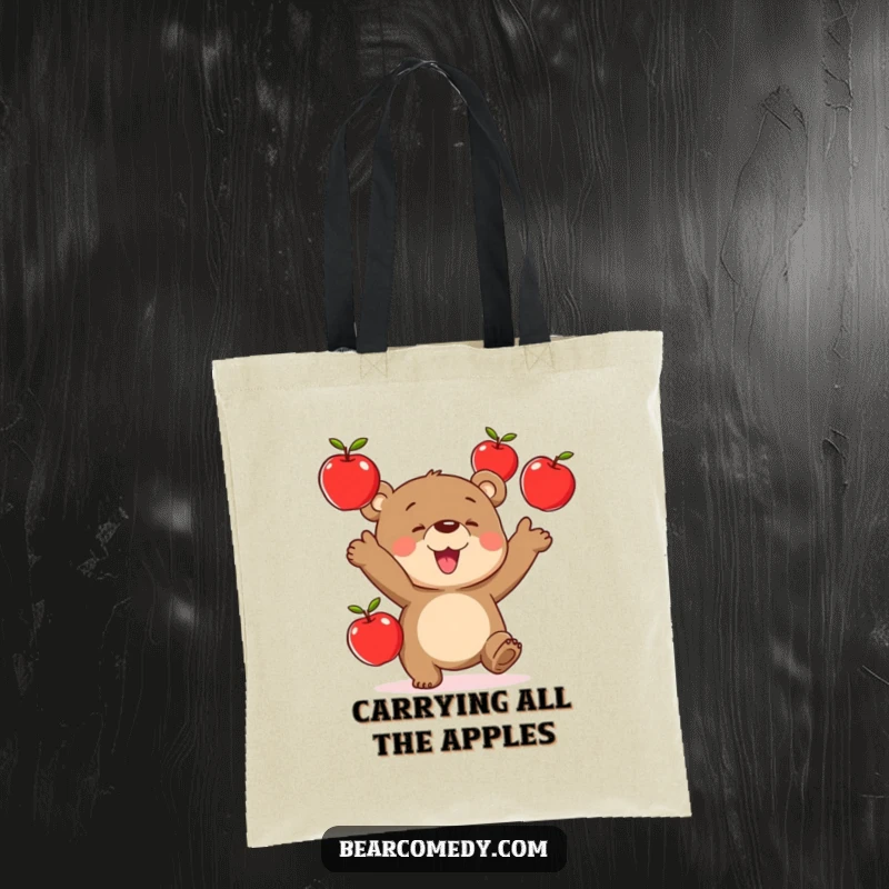 Funny tote bag depicting a bear character expertly juggling three vibrant red apples, showcasing playful skill.